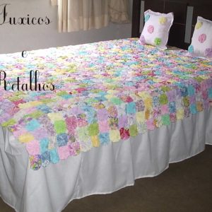 Colcha de Fuxico Clean Luxo Casal colorida exposta sobre uma cama